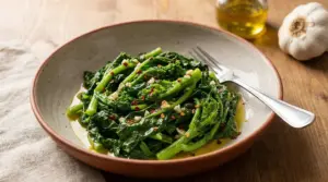 Piatto di cime di rapa saltate con aglio, olio extravergine e peperoncino, servite in una ciotola con forchetta