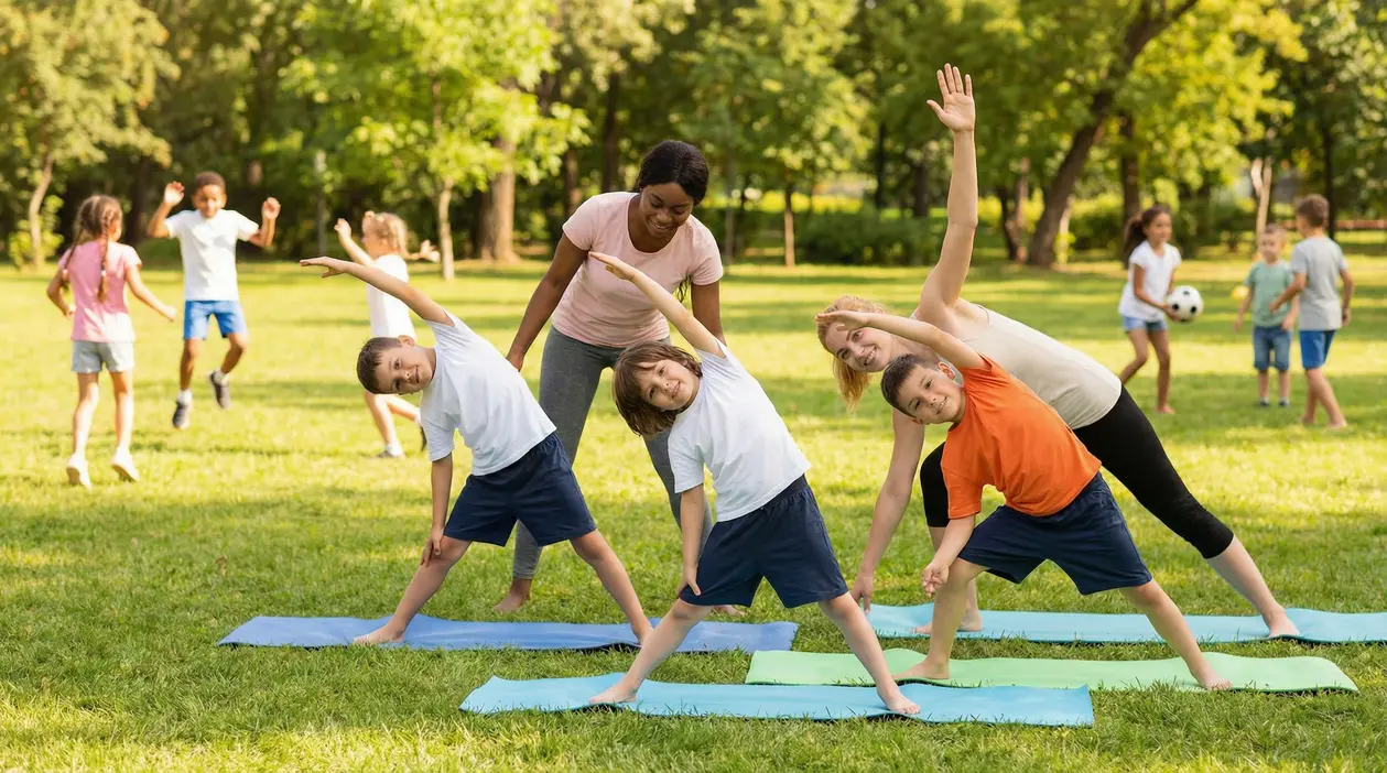 Bambini che fanno esercizi di stretching all'aperto con due istruttrici in un parco