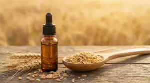 Boccetta di olio di germe di grano con contagocce, chicchi e cucchiaio con scaglie di cereali su tavolo rustico